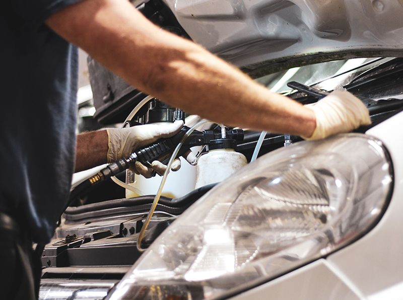 Image of a vehicle technician working on a van engine