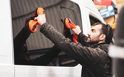 Image of a tinted welfare van window being placed back into place
