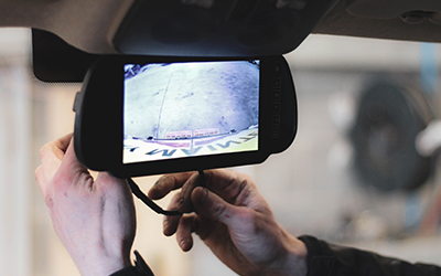Rear parking cam being put into position on front windscreen